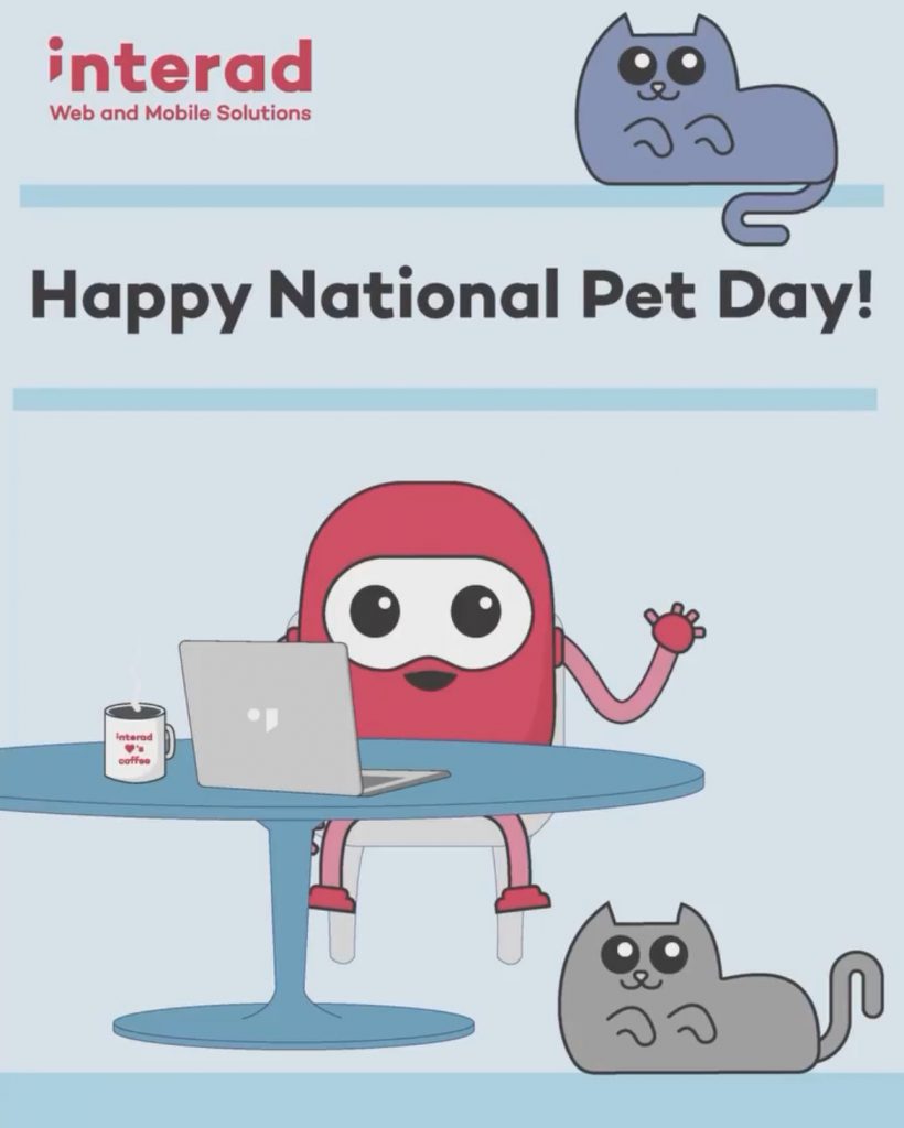 Interad's mascot sits at a table with a iMac, a grey cat rests near its feet and a blue-gray cat sits above the text "Happy National Pet Day!"